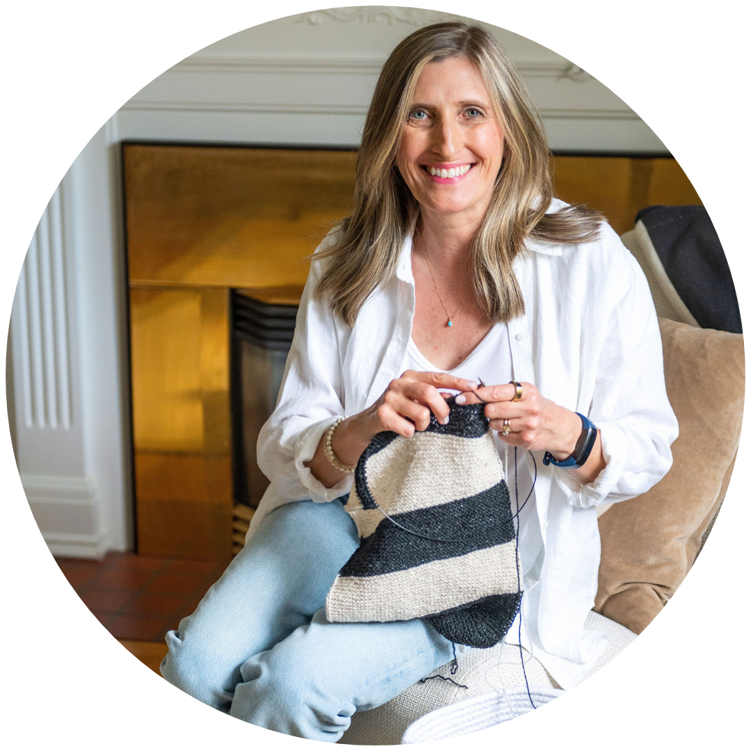 Annika Ek sitting in a chair knitting.