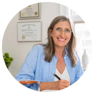 Annika Ek in her office smiling and holding a pen.